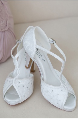 Krásne elegantné svadobné topánky s čipkou a kamienkami na vysokom podpätku.