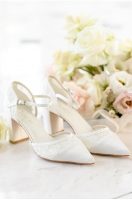 Svadobné topánky so špicatou špičkou zdobené čipkou na hrudnom podpätku.